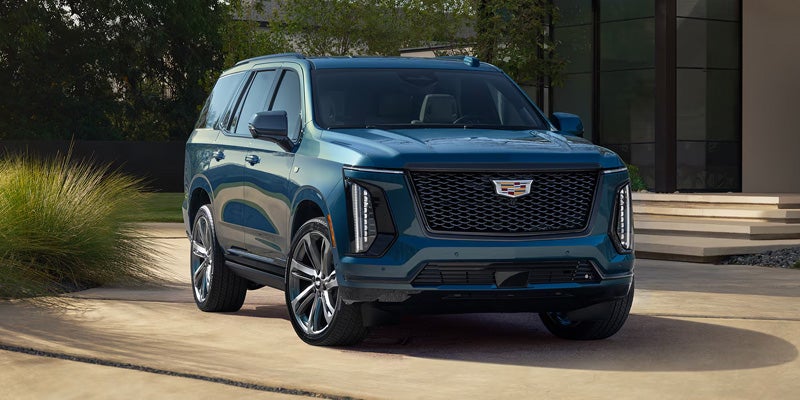 Blue Cadillac Escalade highlighting its bold grille and exterior styling.
